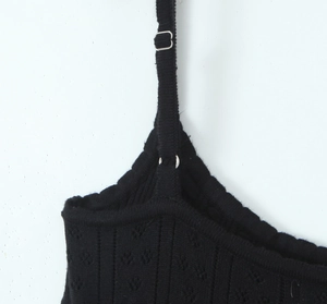 Gros plan sur robe en maille noire avec bretelles réglables et boucle métallique
