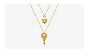 Detailed macro view of 18k gold heart lock and vintage key pendant necklace set