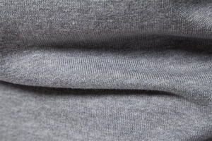Macro shot of high-quality grey knit fabric texture showing fine weave on men cardigan