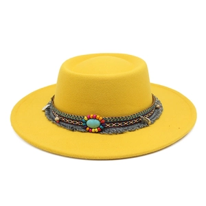 Détail d'un chapeau en feutre de laine jaune avec ruban ethnique, turquoise et franges