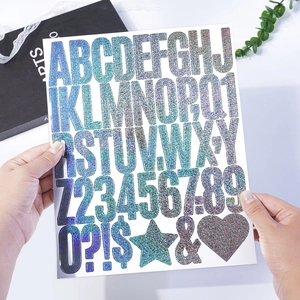 Detail of 2-inch iridescent glitter letter stickers on a bag for DIY gift decoration