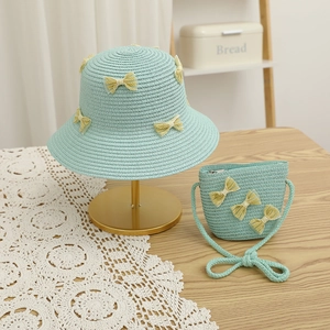 Detail of mint green straw sun hat and matching bag with yellow lace bow decoration