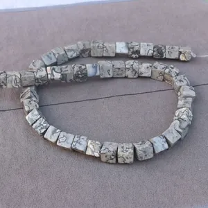 Macro detail of square cut natural stone beads with grey and black marble texture