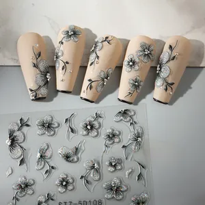 Macro detail of 5D embossed nail art stickers with silver glitter flowers and black vines