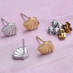 304 stainless steel shell stud earrings in silver, gold and rose gold on purple fabric