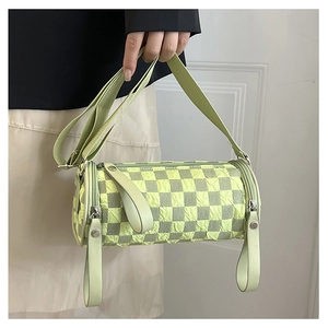 Detail of light green cylinder crossbody bag with checkerboard puff texture and wide strap