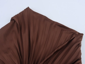 Detailed macro view of dark brown pleated fabric with silk-like sheen and drape