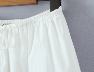 Detail of white lace skirt elastic waist with drawstring and breathable woven texture