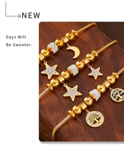 Detail of four gold snake chain bracelets with star, moon, and tree of life charms