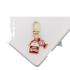 Christmas keychain with Santa pendant and Merry Xmas sign on a white surface