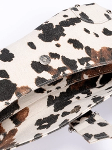 Asymmetric shoulder bag with cow print canvas texture and metallic magnetic closure