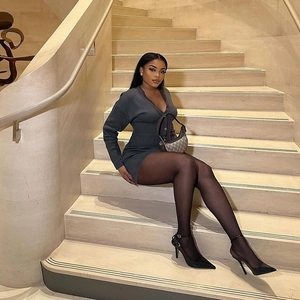 Détail d'une robe en maille gris foncé avec décolleté en V et talons hauts noirs