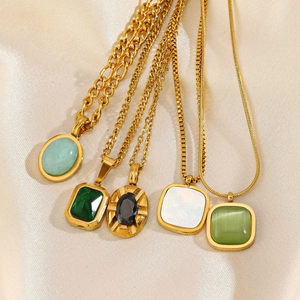 Vintage gold-plated necklaces with natural stone pendants on silk background