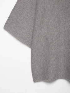 Gros plan sur la texture du tricot gris montrant les coutures fines et les détails