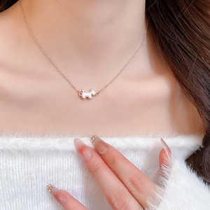 Detail of rose gold necklace featuring a cute white dog pendant on a model's neck