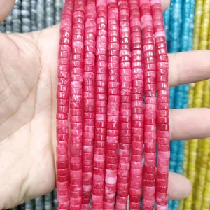 Detail of red natural stone spacer beads for jewelry making, flat cylinder disc shape
