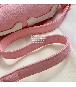 Detail of pink lychee leather strap and cloud-shaped stitching on trendy backpack