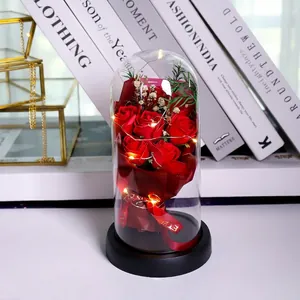 Detail of red soap roses in a glass dome with LED lights and eternal ribbon