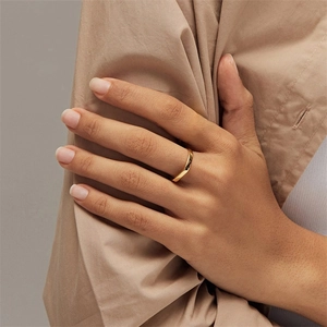 Close-up of a minimalist 18K gold plated stainless steel ring with a polished mirror finish
