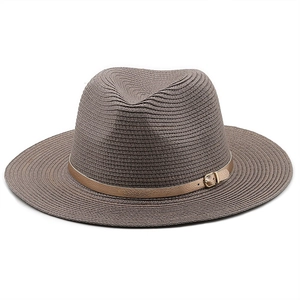 Close-up of brown straw fedora hat featuring a stylish golden leather belt and metal buckle