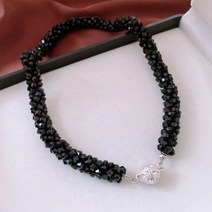Macro detail of multi-layered black faceted crystal beads and rhinestone magnetic clasp