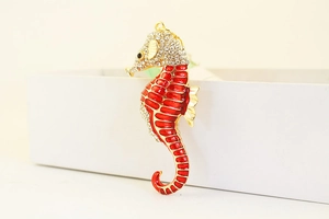 Macro detail of seahorse keychain with red enamel coating and crystal rhinestones