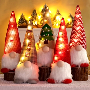 Close-up of five glowing Christmas gnomes with LED lights on a wooden base