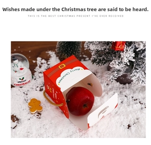 Close-up of a festive red Christmas apple gift box with a golden belt buckle and handle