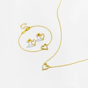 Detailed close-up of S925 sterling silver stamp on golden hollow heart jewelry set