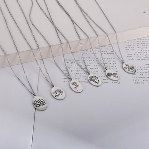 Detail of silver stainless steel oval pendants with six different floral engravings on chains