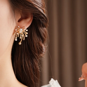 Detail of 18K gold plated fireworks stud earring with pearls and rhinestones on ear