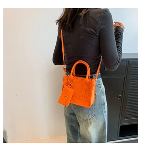 Model wearing orange crocodile pattern PU leather crossbody bag with detachable mini pouch