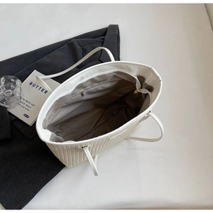 Top view of beige woven tote bag interior with zipper pocket and white leather strap