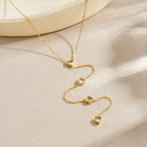 Collier minimaliste en acier doré avec pendentifs cœur en zircon sur fond de pierre