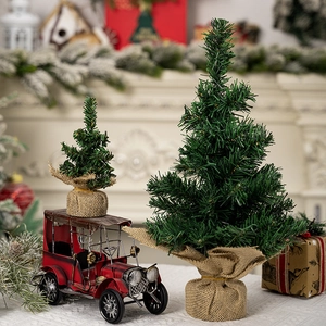 Close-up of mini Christmas trees with burlap bases and a red vintage toy car