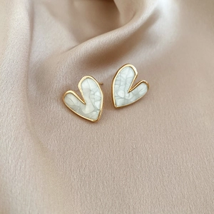 Detailed close-up of heart-shaped studs on elegant silk fabric with marble finish