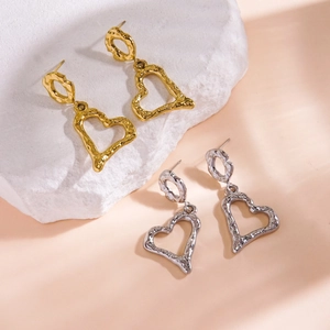 Hammered heart drop earrings in gold and silver finish on white stone decor