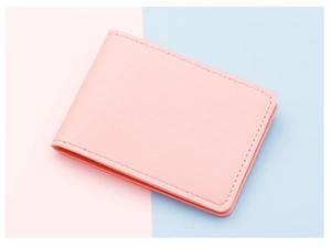 Detail of pink lychee leather card holder with fine stitching on colorful background