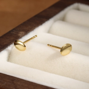 Minimalist s925 silver oval gold stud earrings displayed in white velvet jewelry box