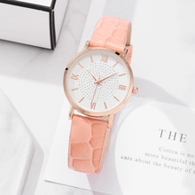 Detail of elegant gold women's watch with white Roman dial and pink leather strap