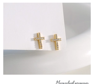 Macro shot of gold cross stud earrings featuring brilliant micro-inlaid cubic zirconia