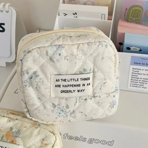Detail der gesteppten Blumentasche aus Stoff mit gesticktem Text auf weißem Etikett