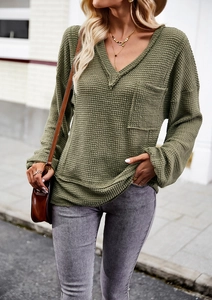 Detail of army green waffle knit V-neck sweater with a functional chest pocket