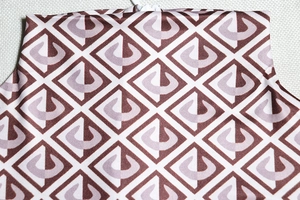 Close-up of geometric pattern on brown and purple knit fabric showing textile texture