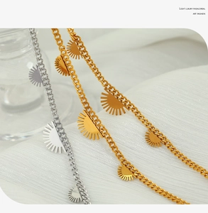 Detailaufnahme goldener und silberner Sonnenanhänger an Panzerketten im modernen Hip-Hop-Stil