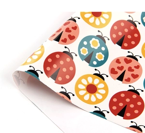 Detailed view of colorful cartoon ladybug patterned wrapping paper roll in various vibrant colors