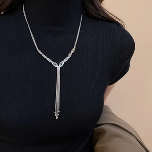 Silver multi-layer tassel necklace worn on a black turtleneck sweater for a stylish look