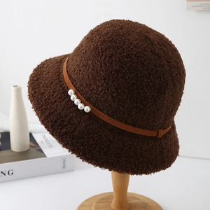 Détail d'un chapeau bob en laine d'agneau marron foncé avec perles élégantes