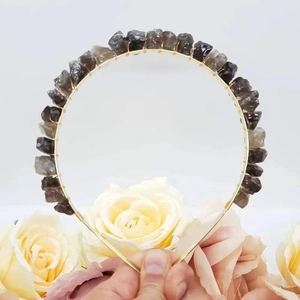 Detailed view of handmade gold wire headband featuring raw dark grey natural crystals