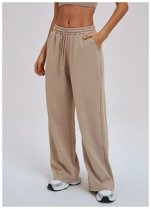 Detail of high-waist beige wide-leg sweatpants showing elastic drawstring waistband and pockets